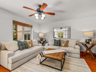 Step into this inviting living room, featuring a spacious sectional sofa adorned with plush throw pillows and a stylish leather ottoman.