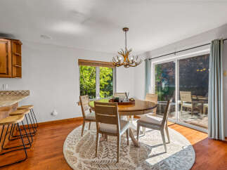 Enjoy meals in this charming dining area featuring a round wooden table with four chairs, all centered on a decorative rug.