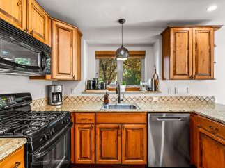This charming kitchen features warm, honey-toned wood cabinetry complemented by a speckled granite countertop.