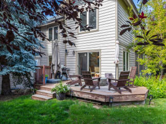 Enjoy outdoor living in this charming backyard featuring a multi-level wooden deck, perfect for entertaining.
