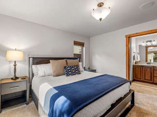 Experience ultimate comfort in this inviting bedroom, featuring a plush king-size bed adorned with crisp white linens and decorative pillows.