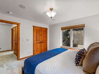 Step into this inviting bedroom featuring a comfortable queen-sized bed adorned with a vibrant blue throw and plush pillows.