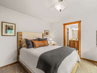 Experience comfort and style in this inviting bedroom, featuring a plush queen-sized bed adorned with decorative pillows and a cozy throw blanket.