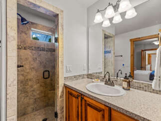 Experience luxury in this beautifully appointed bathroom, featuring a spacious walk-in shower with elegant tile work and a convenient glass door.