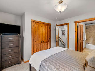 This charming bedroom features a comfortable bed with striped bedding and a plush white throw, perfect for relaxation.