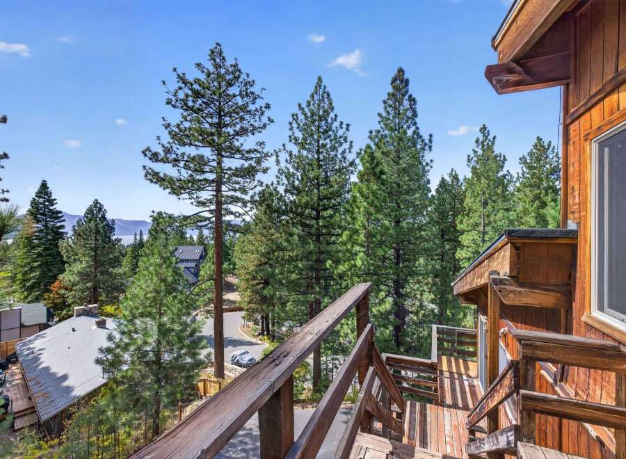 Experience breathtaking lake and mountain views from this charming wooden home, nestled amidst towering pine trees.
