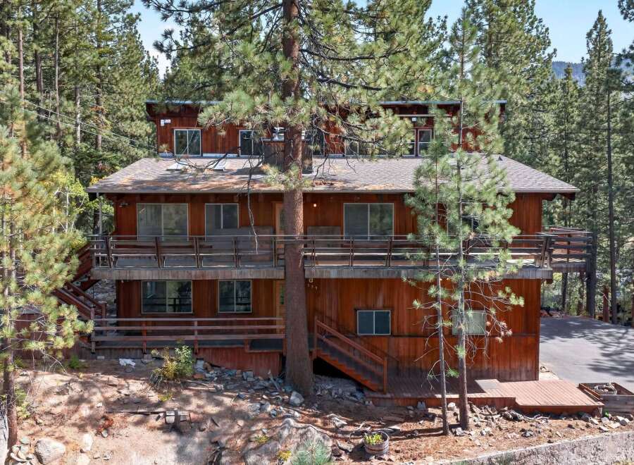 Nestled amidst towering pine trees, this multi-level wooden home offers a serene mountain retreat.