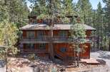 Nestled amidst towering pine trees, this multi-level wooden home offers a serene mountain retreat.