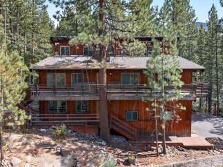Nestled amidst towering pine trees, this multi-level wooden home offers a serene mountain retreat.