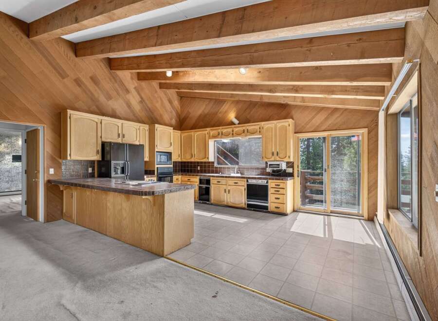 Discover a charming kitchen with rustic wooden beams and paneled walls, creating a warm and inviting atmosphere.