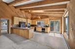 Discover a charming kitchen with rustic wooden beams and paneled walls, creating a warm and inviting atmosphere.