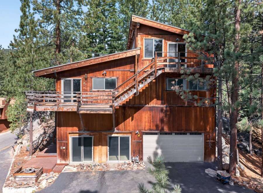 Nestled among tall pine trees, this rustic wooden home offers a unique mountain retreat.