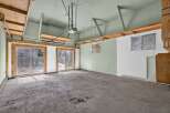 This spacious garage offers ample room for vehicles and storage, featuring large sliding glass doors that provide easy access and natural light.