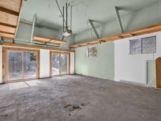 This spacious garage offers ample room for vehicles and storage, featuring large sliding glass doors that provide easy access and natural light.