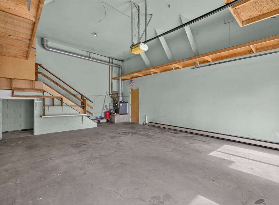 Discover the potential of this versatile garage space, featuring a convenient staircase leading to an upper level for added storage or workspace.