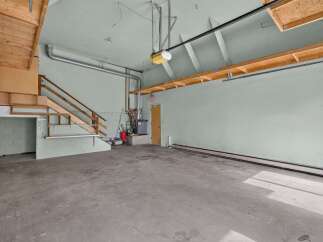 Discover the potential of this versatile garage space, featuring a convenient staircase leading to an upper level for added storage or workspace.