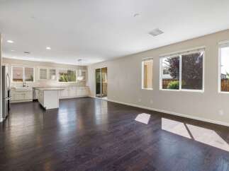 This spacious open-concept living area features a modern kitchen with ample cabinet space, a large island, and a farmhouse sink, perfect for entertaining.