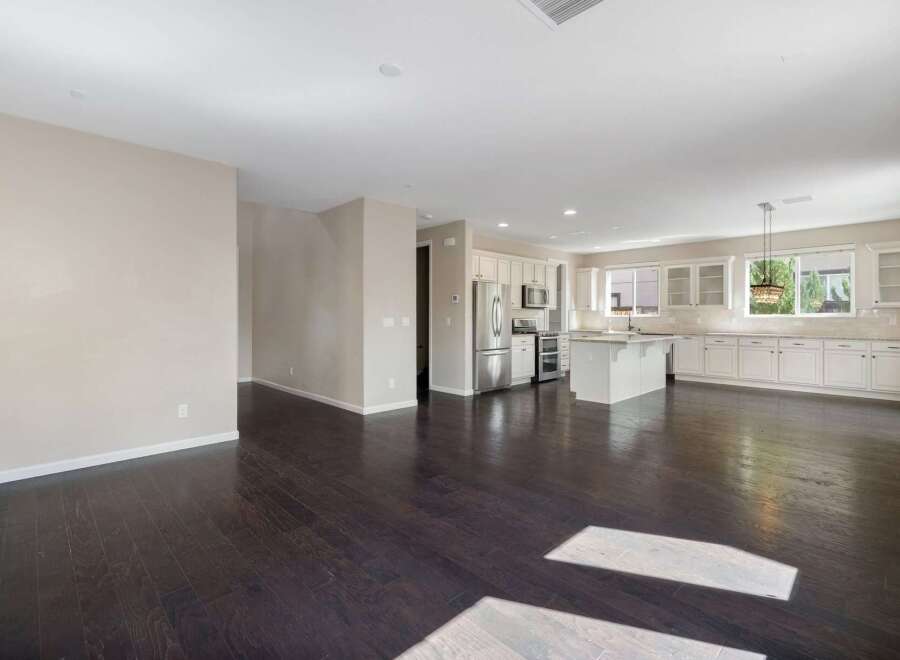 Experience modern living in this spacious open-concept home, featuring a gourmet kitchen with ample white cabinetry and a large island perfect for entertaining.
