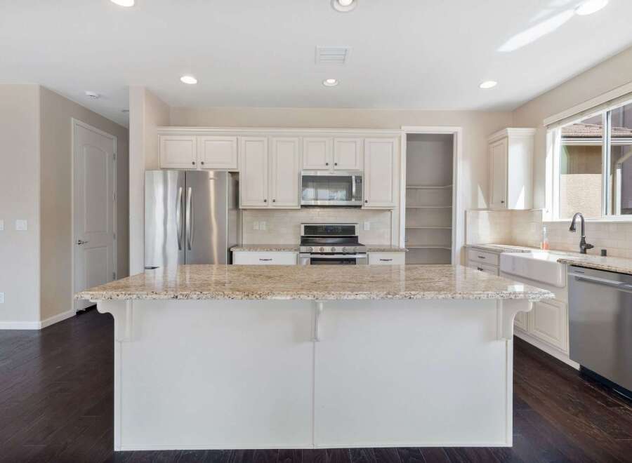 This spacious kitchen boasts a large granite island, perfect for meal prep and entertaining.