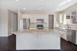 This spacious kitchen boasts a large granite island, perfect for meal prep and entertaining.