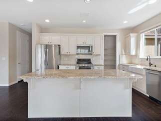 This spacious kitchen boasts a large granite island, perfect for meal prep and entertaining.