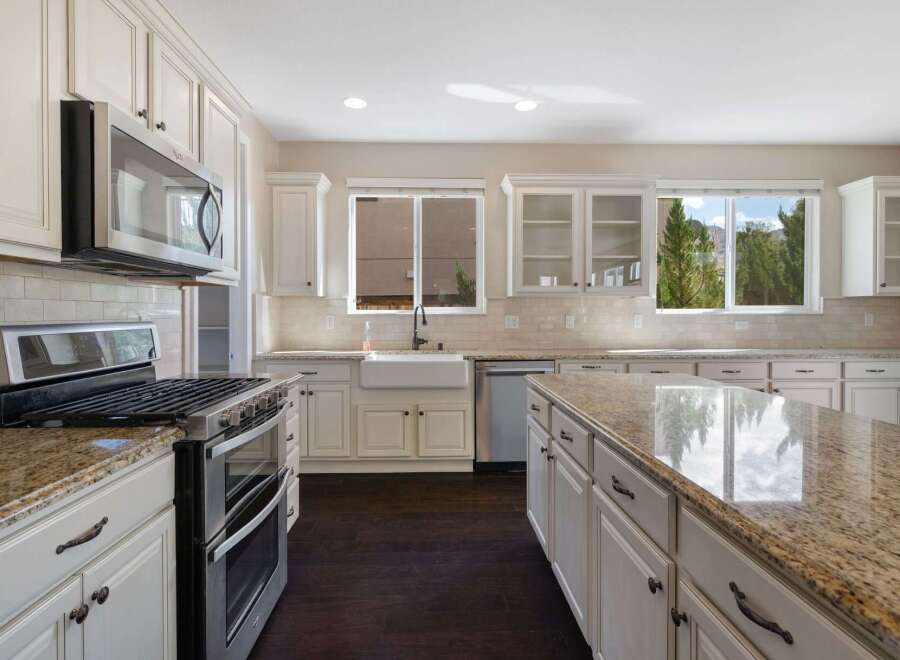 This spacious kitchen boasts elegant cream cabinetry complemented by a stunning granite-topped island, perfect for meal preparation and entertaining.