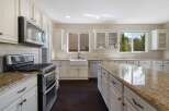 This spacious kitchen boasts elegant cream cabinetry complemented by a stunning granite-topped island, perfect for meal preparation and entertaining.