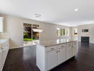 This spacious open-concept kitchen and living area features a large island with granite countertops, perfect for entertaining.