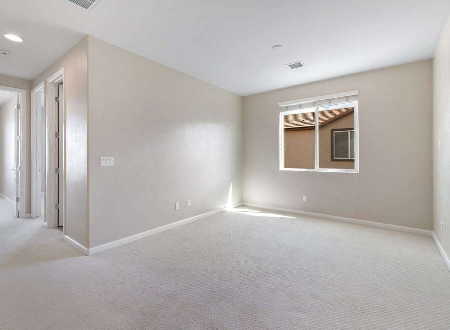 Step into this spacious room featuring plush carpeting and neutral-toned walls, creating a serene and inviting atmosphere.