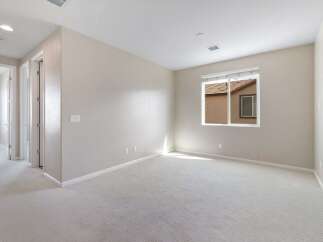 Step into this spacious room featuring plush carpeting and neutral-toned walls, creating a serene and inviting atmosphere.