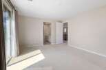 Step into this spacious bedroom featuring a large sliding glass door that floods the room with natural light.