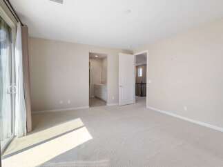 Step into this spacious bedroom featuring a large sliding glass door that floods the room with natural light.