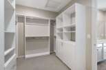 Discover ample storage in this spacious walk-in closet, featuring custom shelving and hanging rods to organize your wardrobe.