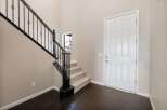 Step into this welcoming entryway featuring a grand staircase with elegant black wrought iron railings.