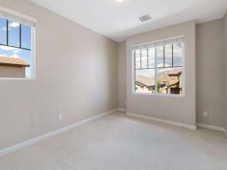 This bright and airy room features two large windows offering scenic views of the surrounding neighborhood and hills.