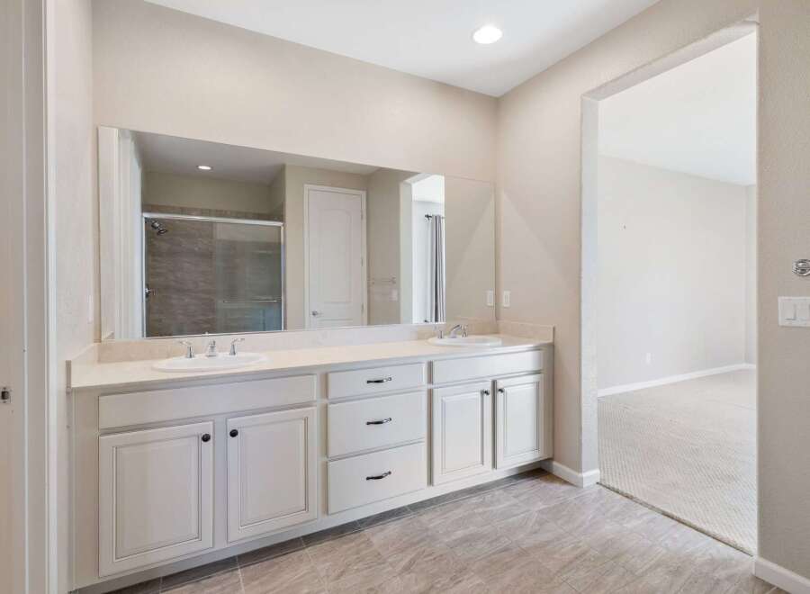 This spacious bathroom features a double vanity with ample counter space and storage, perfect for any household.