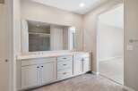 This spacious bathroom features a double vanity with ample counter space and storage, perfect for any household.