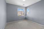 This unfurnished bedroom features light blue walls and a neutral carpet.
