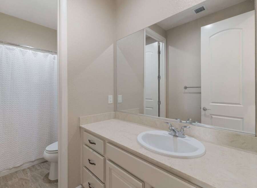 This bathroom features a spacious vanity with ample counter space and storage, perfect for organizing your essentials.