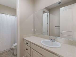 This bathroom features a spacious vanity with ample counter space and storage, perfect for organizing your essentials.