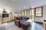 This charming living space seamlessly blends a modern kitchen with a comfortable living area, perfect for entertaining.