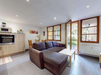 This charming living space seamlessly blends a modern kitchen with a comfortable living area, perfect for entertaining.