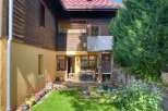 Discover this charming property featuring a rustic wooden exterior and a vibrant yellow-painted lower level.