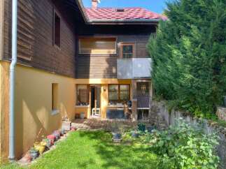 Discover this charming property featuring a rustic wooden exterior and a vibrant yellow-painted lower level.