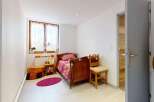 This charming bedroom features a cozy wooden bed with colorful bedding, perfect for a restful night's sleep.