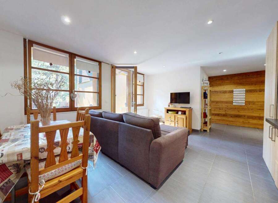 Discover this charming living space featuring a cozy dining area with a wooden table and chairs, perfect for intimate meals.