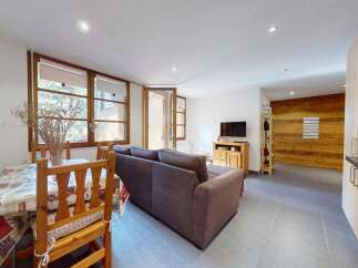 Discover this charming living space featuring a cozy dining area with a wooden table and chairs, perfect for intimate meals.