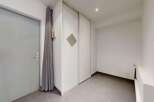 Discover this spacious entryway featuring a sleek gray door and convenient built-in closet space.