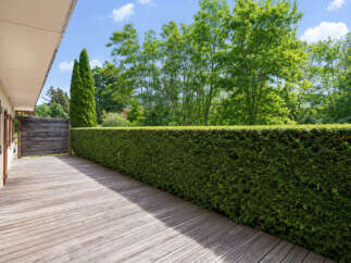 Enjoy the serene outdoors from this charming wooden deck, perfect for morning coffee or evening relaxation.