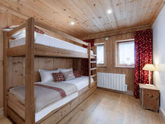 Experience cozy mountain living in this charming bedroom featuring a sturdy wooden bunk bed with comfortable bedding.